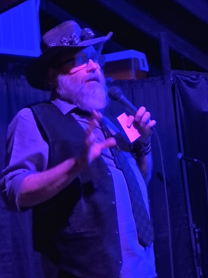 Big Daddy Voodoo announcing on stage in costume with his trademark skull hat and microphone